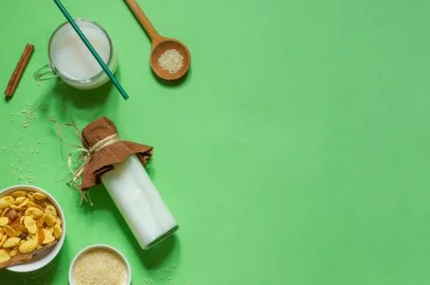 Top view on a bright green background with a bottle of rice milk, corn flakes Stock Photos