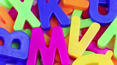 Top view of bright multicolored letters rotating as a background close up Stock Footage 235660025
