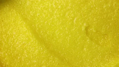Top view of bright yellow lemon exfoliating sugar body scrub texture smears Video stock 234780782