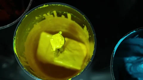 Top view of bright yellow paint being automatically mixed in a container Stock Footage 330349155