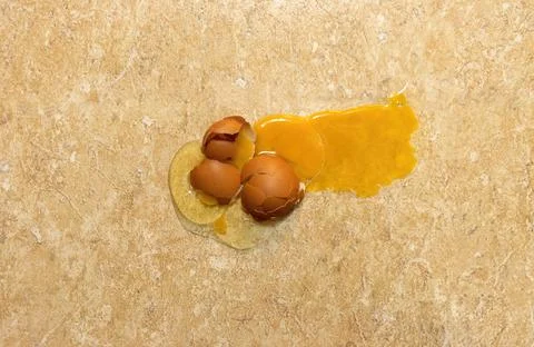 Top view of a broken egg, slapped against the floor of a kitchen Stock Photos