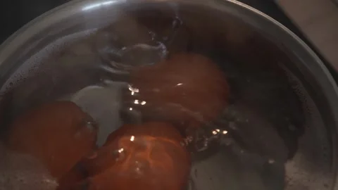 Top view of brown eggs swirling in boiling water inside pot Stock Footage 312767225