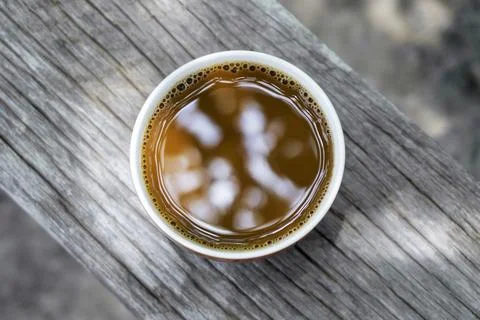 Top view of a brown hot coffee cup on an old wood table vintage style with .. Stock Photos