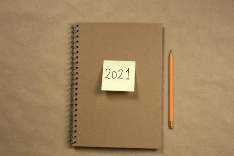 Top view of Brown notepad and yellow sticky note with 2021 New Year's message Stock Photos