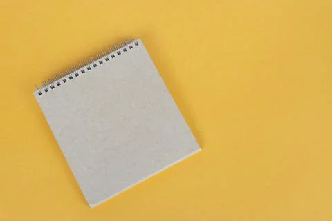 Top view of brown notepad on yellow background. Copy space. Stock Photos