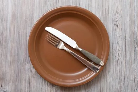 Top view of brown plate with flatware on gray Stock Photos