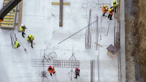 Top view: builders in orange and yellow uniform at the construction site Stock Footage 236473833