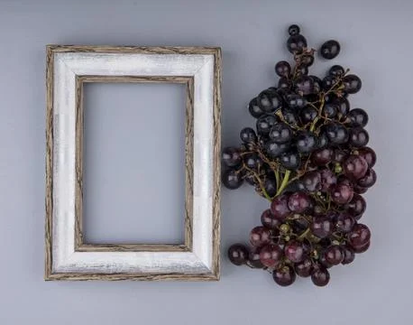 Top view of bunch of black grape and frame on gray background with copy space Stock Photos