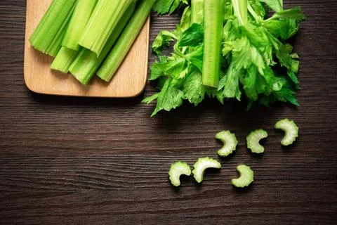 Top view of bunch of fresh sliced celery stalk on wooden table with leaves... Stock Photos