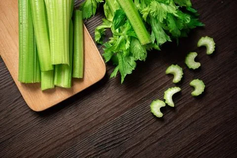 Top view of bunch of fresh sliced celery stalk on wooden table with leaves... Stock Photos