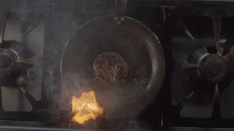 Top view of burger cutlet fried in blazing fire in pan. Slow motion video Stock Footage 123046511