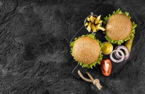 Top view burgers fries cutting board with pickles copy space Stock Photos