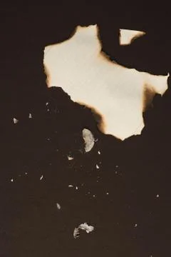 Top view of burned pieces of empty writing paper sheet isolated on black Stock-Fotos