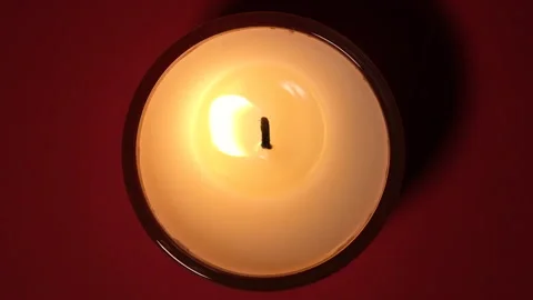 Top view on Burning candle close up on a dark red background. Slow motion full Stock Footage 159311079
