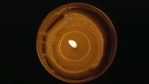 Top view of a burning candle with a warm flame in the darkness 库存影片 348269459