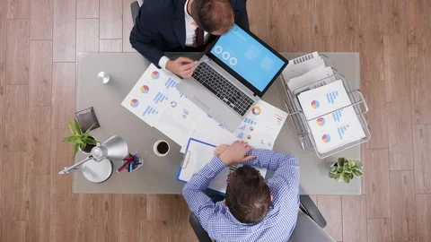 Top view of businessman in suit explaining charts from his laptop Stock Footage 114902262