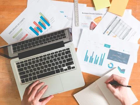 Top view of Businessman using laptop with analyzing investment charts on th.. Stock Photos