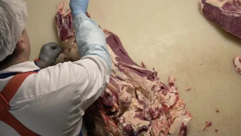 Top view of Butcher cut raw meat with knife at table in slaughterhouse. Male Stock Footage 156055973