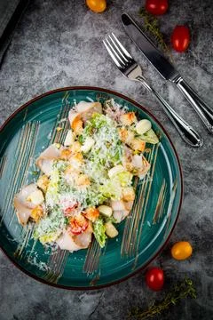 Top view of caesar salad with cheese on a blue plate Stock Photos