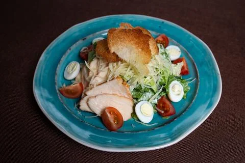 Top view of Caesar salad with chicken, fresh lettuce leaves and baked bread Foto stock