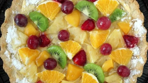 Top view of cake with fresh fruit and berries with cream rotates on tray Stock Footage 141043776