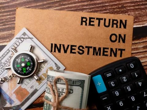 Top view calculator,banknotes,compass with text RETURN ON INVESTMENT Stock Photos