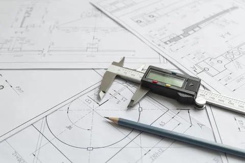 Top view of a caliper measuring tool, pencil and detail drawings.Engineering  Stock Photos