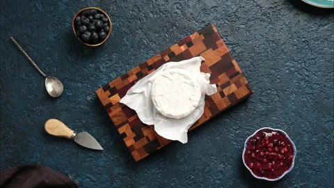 Top view of Camembert cheese being cut on a beautiful wooden board and deco.. Stock Footage 262958379