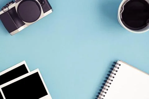 Top view camera, coffee, notepad, photo frames on blue background Stock Photos