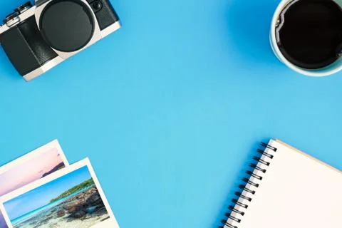 Top view camera, coffee, notepad, photo frames on blue background Stock Photos
