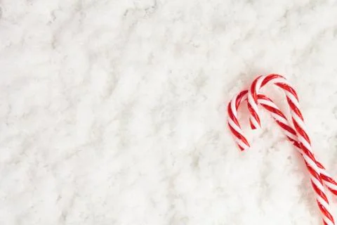 Top view of candy canes on snow with copy space. Christmas background Stock Photos