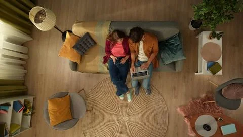 Top view capturing a young couple sitting on the couch, hugging and talking Stock Photos