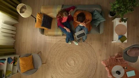 Top view capturing a young couple sitting on the couch, hugging and talking Stock Photos