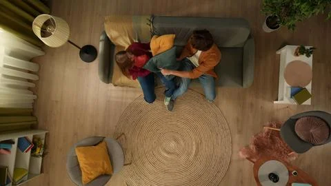 Top view capturing a young couple sitting on the couch in front of each other Stock Photos