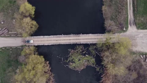 Top view car driving across the river on a wooden bridge Stock Footage 154098239