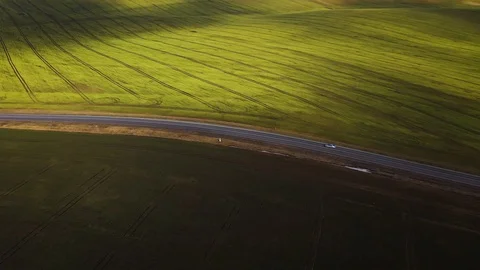 Top view of a car driving along a rural road between two fields Stock Footage 104656995