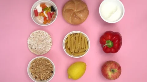 Top view of carbohydrate sources on pink background. Video stock 249552306