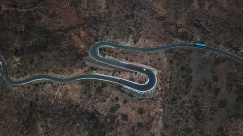 Top view of cars driving on zig zag meandering road through rocky terrain on Stock Footage 94113105