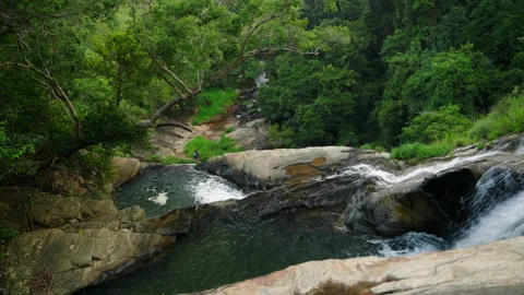 Top view of cascading waterfall in lush forest. Freshwater stream flows over Stock Footage 274549001