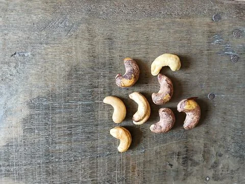 Top view cashew nuts scattered on old rustic wooden surface Stock Photos