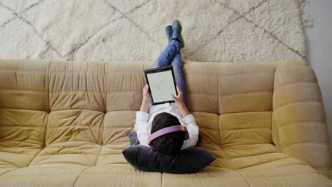 Top view of a caucasian boy with helmets playing with a tablet sitting on the Stock Footage 150664782