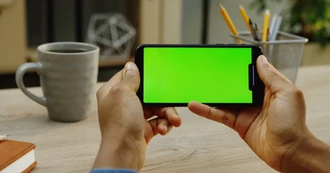 Top view on the Caucasian man's hands holding black smartphone horizontally on Stock Footage 83063110
