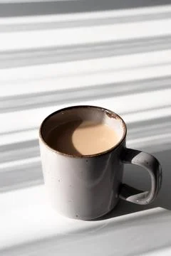 Top View of Ceramic Mug of Coffee or Tea Casting a Strong Shadow on White S.. Stock Photos