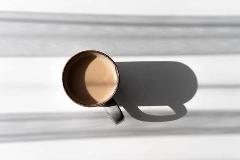 Top View of Ceramic Mug of Coffee or Tea Casting a Strong Shadow on White S.. Stock Photos