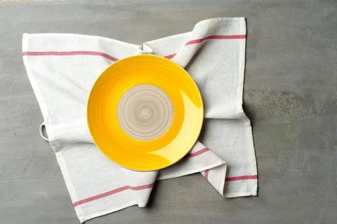 Top view of ceramic plate with table napkin on gray background Foto stock