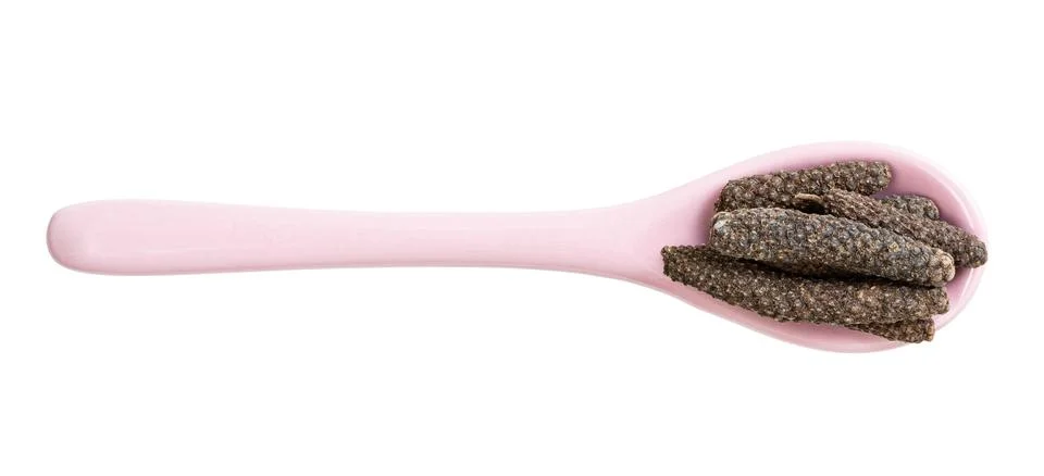 Top view of ceramic spoon with java long peppers Photos
