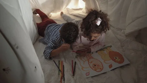 Top view of charming mixed race brother and sister play lying in makeshift house Stock Footage 115576092