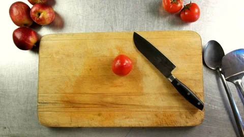 Top view chef cuts a tomato into half rings and slices on a cutting board Stock Footage 76097114