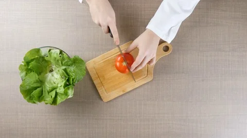 Top view of chef hands cutting tomatoes on wooden board Stock Footage 84100816