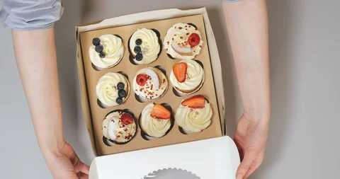 Top view of chef packing delicious decorated muffins Stock Footage 129325032